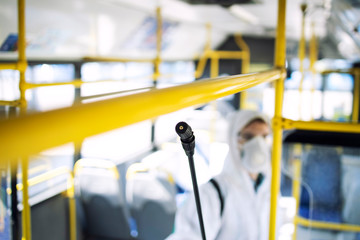 Disinfecting passenger handlebars of public bus transportation to stop spreading highly contagious coronavirus or COVID-19.