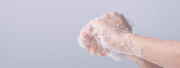 Washing hands. Asian young woman using liquid soap to wash hands, concept of hygiene to protective pandemic coronavirus isolated on gray white background, close up.