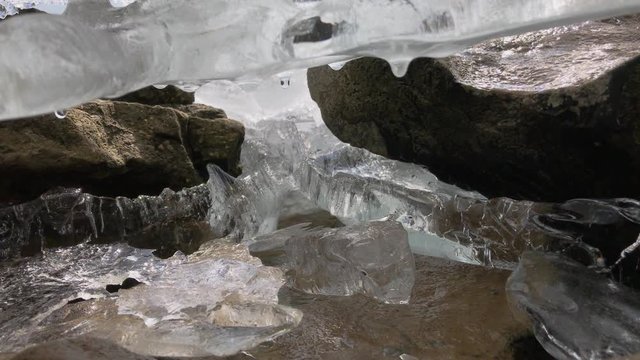 The ice that melts in the spring on the river drips and is sprinkled with sharp parts