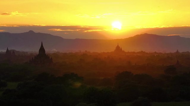 Plain of Bagan in misty morning with sunbeams, Myanmar at sunrise, Silhouette Balloons Over Ancient Empire Bagan Of Myanmar with light flare.