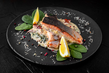 Grilled fish in a sauce with vegetables. A piece of sturgeon, salmon, trout, dorado. Healthy food.