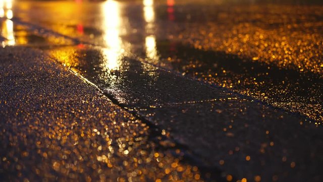 Bright headlights and street lights reflection on night city street after rain 