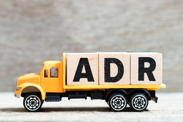 Truck hold letter block in word ADR (Abbreviation of Adverse drug reaction) on wood background