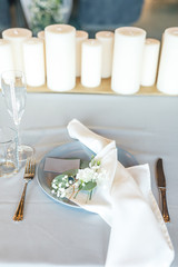 banquet table is decorated with plates, cutlery, glasses, candles and flower arrangements