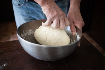 male hands making bread in kitchen at home