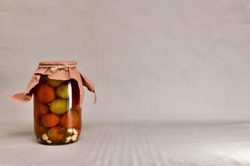 Canned by the lid of the jar with fermented tomatoes.