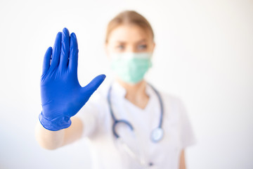 Hands blue doctor's protective gloves showing stop gesture, not allowed