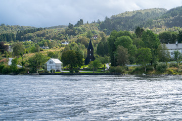 Fototapeta na wymiar August 2019: Unusual black church on the shore of the fjord near Bergen city, Norway.