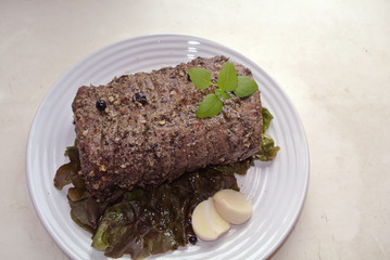 Beef and beef meat in a glass plate. Roast beef in spices. Cooking meat marinating in spices and herbs