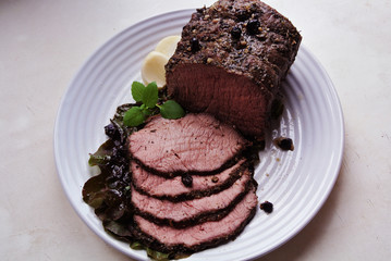 Beef and beef meat in a glass plate. Roast beef in spices. Cooking meat marinating in spices and herbs