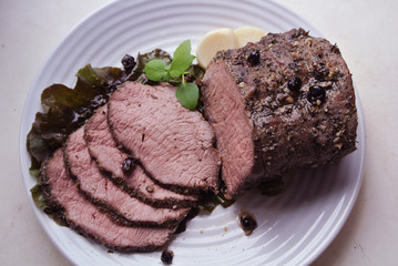 Beef and beef meat in a glass plate. Roast beef in spices. Cooking meat marinating in spices and herbs