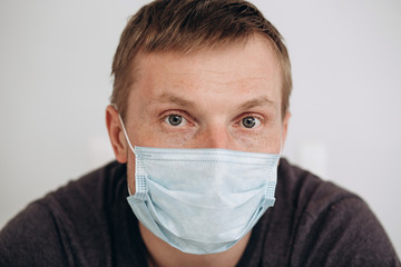 Protection against contagious disease, coronavirus. The man of European appearance wearing hygienic mask to prevent infection, airborne respiratory illness such as flu, 2019-nCoV, on white background.