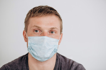 Protection against contagious disease, coronavirus. The man of European appearance wearing hygienic mask to prevent infection, airborne respiratory illness such as flu, 2019-nCoV, on white background.
