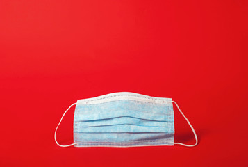 Medical mask in the center on a red background. Copy space