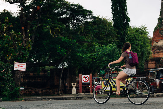Woman riding a bicycle  near Ayutthaya historical park in Thailand,