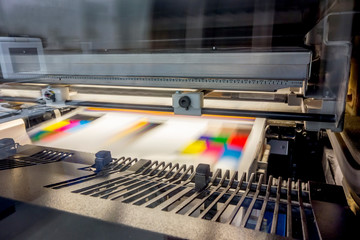 高速で印刷排紙される枚葉印刷機のアップ。 - obrazy, fototapety, plakaty