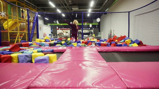Children jumping on trampolines indoors, having fun on trampoline at local amusement park.