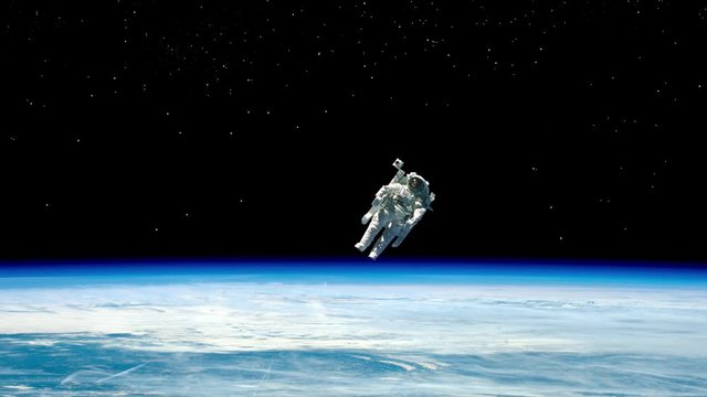 Astronaut in space, in zero gravity near the planet Earth. Astronaut in orbit in free flight, planet earth and space. Elements of this image furnished by NASA.