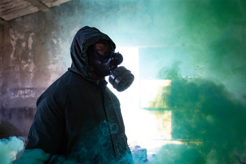 Dramatic portrait of a man wearing a gas mask in a ruined building.