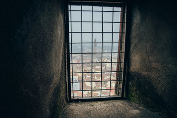 Palazzo Vecchio and the centre of Florence seen through the metal fence from the dome of Florence Cathedral on a foggy day