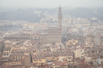 Fototapeta premium view of Palazzo Vecchio and Loggia dei Lanzi from the dome of the Duomo in Florence on a foggy day