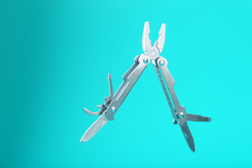 The multitool multi-function tool hovers on a blue background. The concept of an expanded multi-tool with free space.