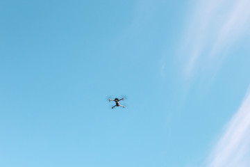 Flying drone against the blue sky.