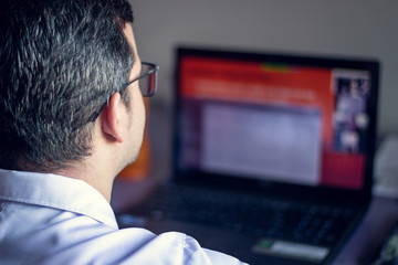 Teacher preparing his class in the computer.