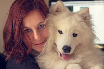 Model posing with gorgeous Samoyed smiling for photo.