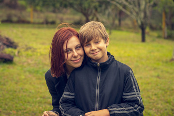 Mother and son posing for photo in the park.