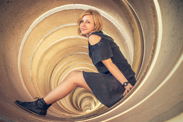 Blonde model posing on a cement tunnel.