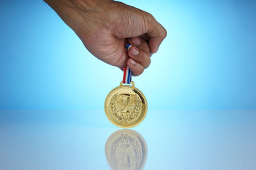The gold medal is a symbol of the champion. The champion holds a gold medal in his hand