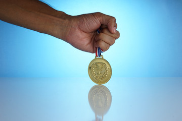 The gold medal is a symbol of the champion. The champion holds a gold medal in his hand