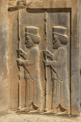 starożytne płaskorzeźby wykute w kamieniu  na jednej ze ścian w persepolis w iranie przedstawiające  szereg mężczyzn © KOLA  STUDIO