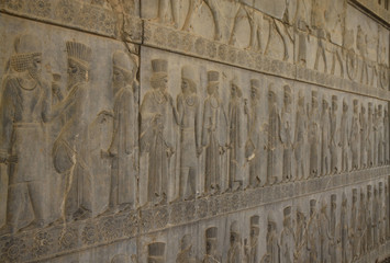 starożytne płaskorzeźby wykute w kamieniu  na jednej ze ścian w persepolis w iranie przedstawiające  szereg mężczyzn © KOLA  STUDIO