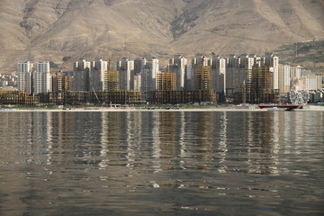 osiedle apartamentowców położone nad jeziorem w górach w iranie - obrazy, fototapety, plakaty