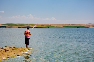 amateur fishing with fishing rod on the lake