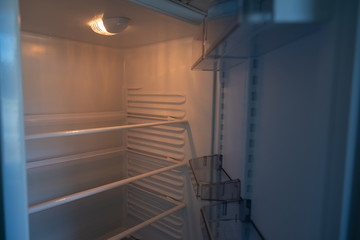 Obraz premium Empty shelves in refrigerator. The concept of diet and hunger