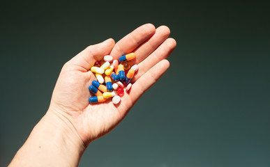 Colorful pills and medicines in the hand.