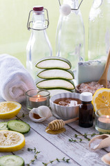 A vertical view of various natural beauty and wellness remedies including lemon, honey and aloe.
