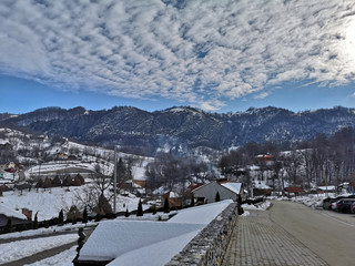 Photo of mountains in Romania, snowy landscape with cloud formations , blue sky and the Carpathian mountain range in Ponoarele, Mehedinti - 01/01/2019