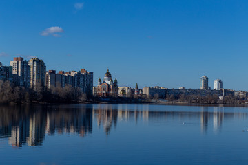 Fototapeta na wymiar view of Kiev from the side of the river Dnieper in sunny weather blue water, blue clear sky Ukraine