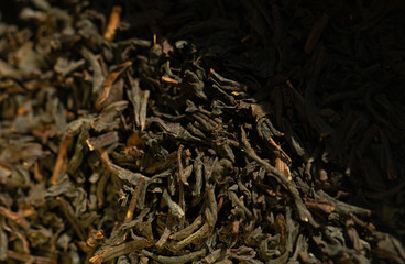 Black tea background. Dry tea leaves.