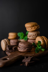 French macaroons on wooden table and black background. Selective focus 