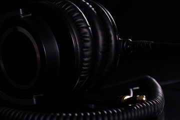 Macro details of black leather headphones on black background