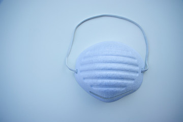 White medical mask isolated. Face mask protection against  virus, flu and coronavirus. Light blue background.