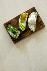 Rustic homemade cottage cheese with herbs, cream cheese. Sandwiches with homemade cheese, pickled cucumber, green onion and egg. Top view, side view, text space