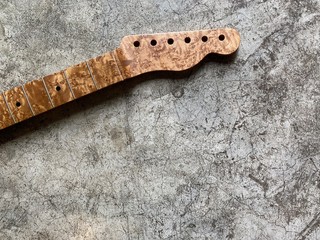 Bird eye maple guitar neck on old grey concrete with space. concept for wallpaper and writing text