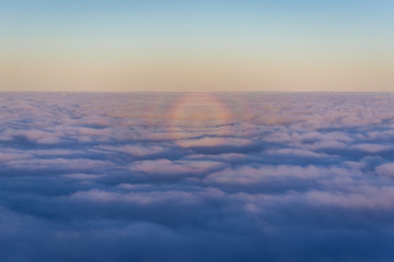 Fototapeta na wymiar Optical phenomenon over moring clouds seen from plane window