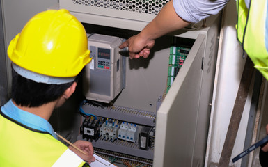 Senior electrician engineer pointed at the power generator and talked with junior engineer at the...
